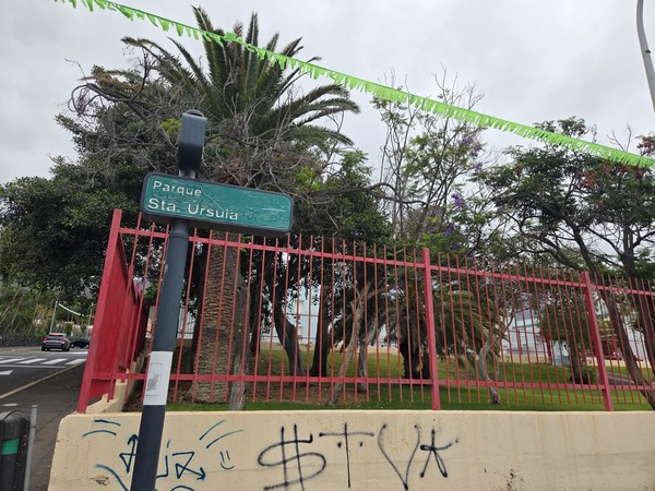 Cartel de entrada al Parque Santa Úrsula rodeado de palmeras.